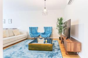 ein Wohnzimmer mit einem Sofa und blauen Stühlen in der Unterkunft Benfica Prime Terrace by Homing in Lissabon