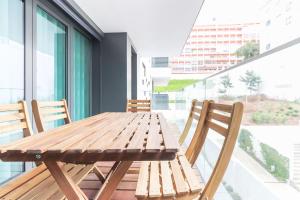 einen Holztisch und Stühle auf dem Balkon in der Unterkunft Benfica Prime Terrace by Homing in Lissabon