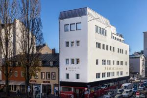 a tall white building on a city street at OneBavariaHomes in Munich