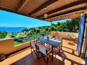 ポルト・ヘリにあるVilla Alti Porto Cheliのテーブルと椅子付きの家のバルコニーから景色を望めます。