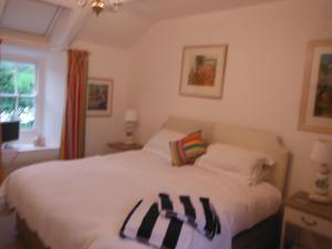a bedroom with a bed with black and white pillows at Beautiful Nancherrow Cottage in St. Just