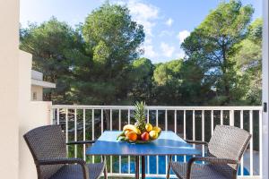 un cesto di frutta su un tavolo blu sul balcone di Apartamentos Cala Murada Minigolf a Cala Murada