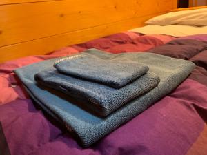 un mucchio di asciugamani seduti sopra un letto di Attico Vista Tofane a Cortina dʼAmpezzo