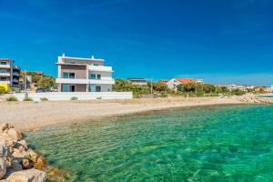 a view of a beach with a building in the background at Villa Eni apartments 2 in Mandre