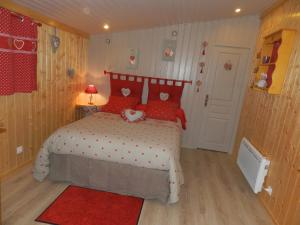 een slaapkamer met een bed met rode kussens en een rood tapijt bij Chambre D'hôte "Les Tourtereaux" in Saint-Just-de-Claix