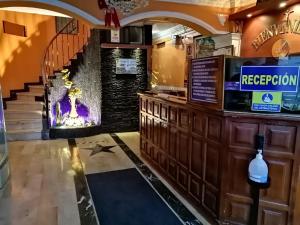 a bar with a fireplace and a staircase in a room at Hotel Allegria in Quito