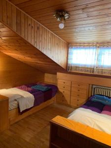 een slaapkamer met 2 bedden in een houten hut bij Attico Vista Tofane in Cortina dʼAmpezzo