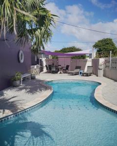 a swimming pool in a yard with a patio at Cadushi Apartments in Oranjestad