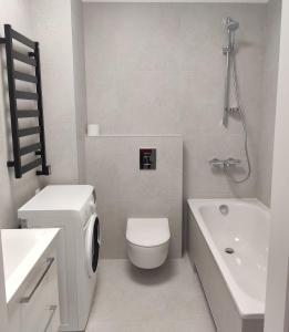 La salle de bains blanche est pourvue de toilettes et d'un lavabo. dans l'établissement Apartment Ainiai, à Panevėžys