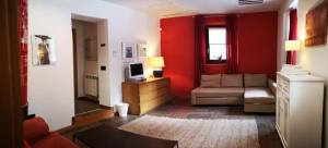 sala de estar con paredes rojas y sofá en Casa Rural Laguna Negra, en Vinuesa