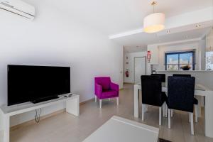 a living room with a television and a table with chairs at One Bedroom Apartment in Albur Village 1A in Alvor