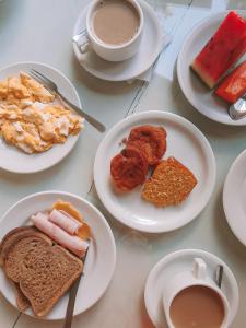 - une table avec des assiettes de produits pour le petit-déjeuner et une tasse de café dans l'établissement Pousada Baía Dos Corais, à Tamandaré