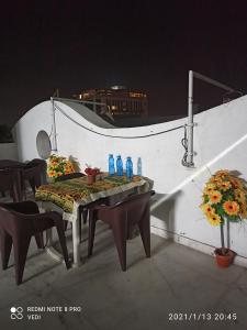 Dormitory في أودايبور: طاولة وكراسي على شرفة مع زجاجات المياه