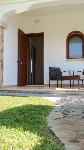 una casa con dos bancos sentados en un patio en Baia, en Budoni