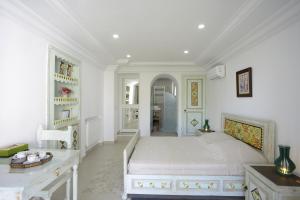 a white bedroom with a large bed in a room at Dar El Yasmine Tunis in Tunis