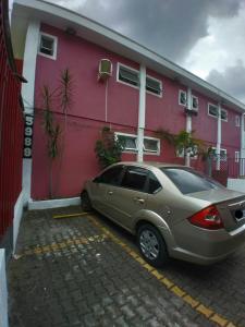 a car parked in a parking lot in front of a building at Hotel Faf's in Sao Paulo