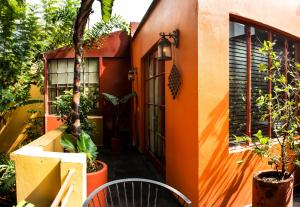 una casa naranja con plantas, mesa y sillas en The Red Tree House, en Ciudad de México