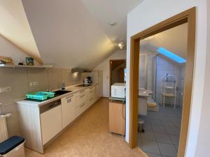 eine große Küche mit weißen Schränken und einem Waschbecken in der Unterkunft Birnbaumhof - Hotel Pension und Ferienwohnungen in Schwedelbach