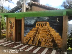 un mural de la pirámide de mastops en un lateral de un edificio en RENTA DE CABAÑAS, Centro Ecoturistico Rural Sustentable Labor San José en San Cristóbal de Las Casas