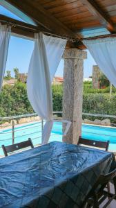 una mesa azul y sillas frente a una piscina en Aria, en Budoni