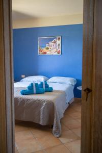 1 dormitorio azul con 1 cama con paredes azules en Aria, en Budoni