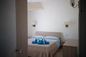 a bedroom with a bed with blue towels on it at Incanto in Budoni