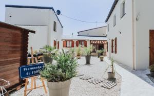 a courtyard with potted plants in front of a building at La Deauvillaise CLS Deauville in Deauville