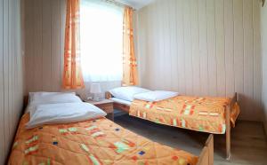 two beds in a small room with a window at Ośrodek Wypoczynkowy "Na fali" in Jarosławiec