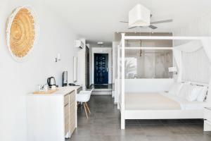 a white bedroom with a bunk bed and a desk at Samothraki Beach Boutique Hotel in Makrilies
