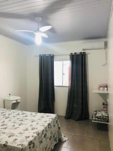 una camera con letto e ventilatore a soffitto di Kitnet em Imbituba - Fabi a Imbituba