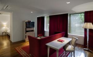 uma sala de estar com um sofá vermelho e uma mesa em Faena Hotel Buenos Aires em Buenos Aires