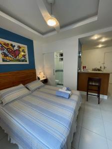 a bedroom with a large bed and a kitchen at Apartamentos em Ipanema in Rio de Janeiro