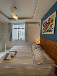 um quarto com uma cama grande e uma janela em Apartamentos em Ipanema no Rio de Janeiro