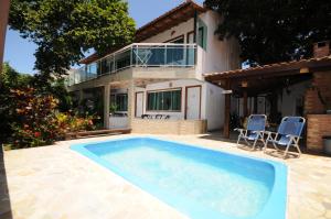 a swimming pool in front of a house at MARESIA Porto da Barra in Búzios