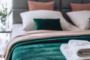 łóżko z zielonym i białym kocem i poduszkami w obiekcie Willa Gardenia w Zakopanem