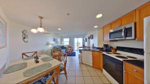 a kitchen with a table and a stove top oven at Vistas on the Gulf by Travel Resort Services in St Pete Beach