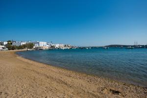 a sandy beach with boats in the water at Ostria Studios & Apartments in Aliki