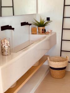 baño con estantes blancos y lavamanos en Ios Art Studios & Luxury Apartments, en Ios Chora