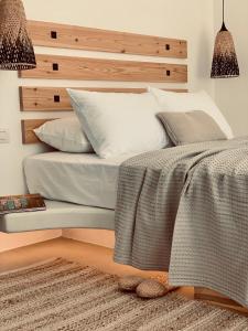 a bedroom with a bed with a wooden headboard at Ios Art Studios & Luxury Apartments in Ios Chora