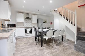 a kitchen and dining room with a table and chairs at Perfect Location with Parking - Jersey House - TV in every Bedroom! in Swansea