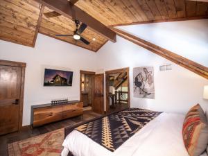 a bedroom with a large bed and wooden ceilings at Relax in Luxury - Jacuzzi, Indoor/Outdoor Fireplace in Estes Park