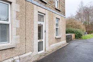 a brick building with a door on the side of it at Perfect Location with Parking - Jersey House - TV in every Bedroom! in Swansea