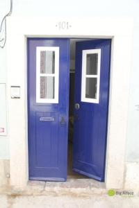 a blue door and windows in a building at Big Alface in Lisbon