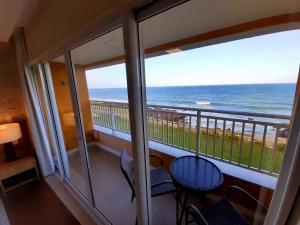 a balcony with chairs and a view of the ocean at Hotel Senac Barreira Roxa in Natal