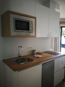 cocina con fregadero y microondas en Apartamentos Corona Playa, en Playa del Inglés