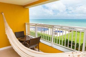 een balkon met een hangmat en uitzicht op de oceaan bij Hotel Senac Barreira Roxa in Natal