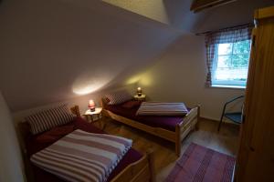 um pequeno quarto com 2 camas e uma janela em Landhaus Rundblick im Elbsandsteingebirge bei Bad Schandau em Rathmannsdorf