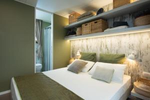 Un dormitorio con una cama blanca y una pared con estanterías. en Papafigo Camping, en Vodnjan