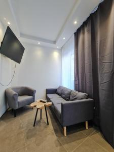 a living room with a couch and two chairs at check-inn hotels - Essen in Essen