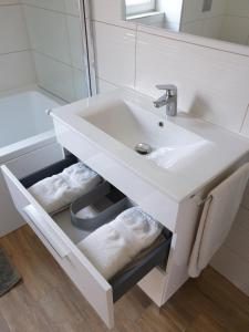 a bathroom with a white sink and a mirror at Mártika Apartment in Siófok